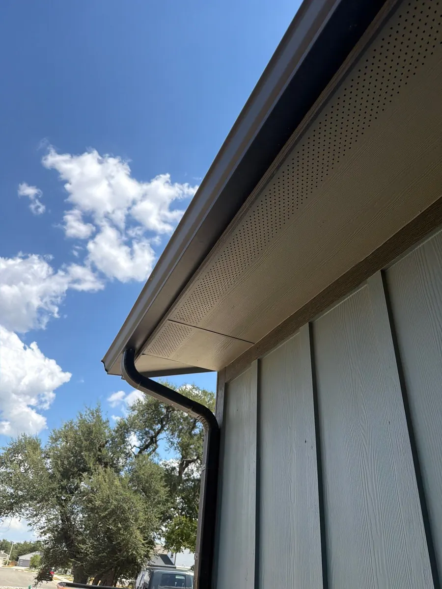 Dark bronze gutter and downspout on a board-and-batten house