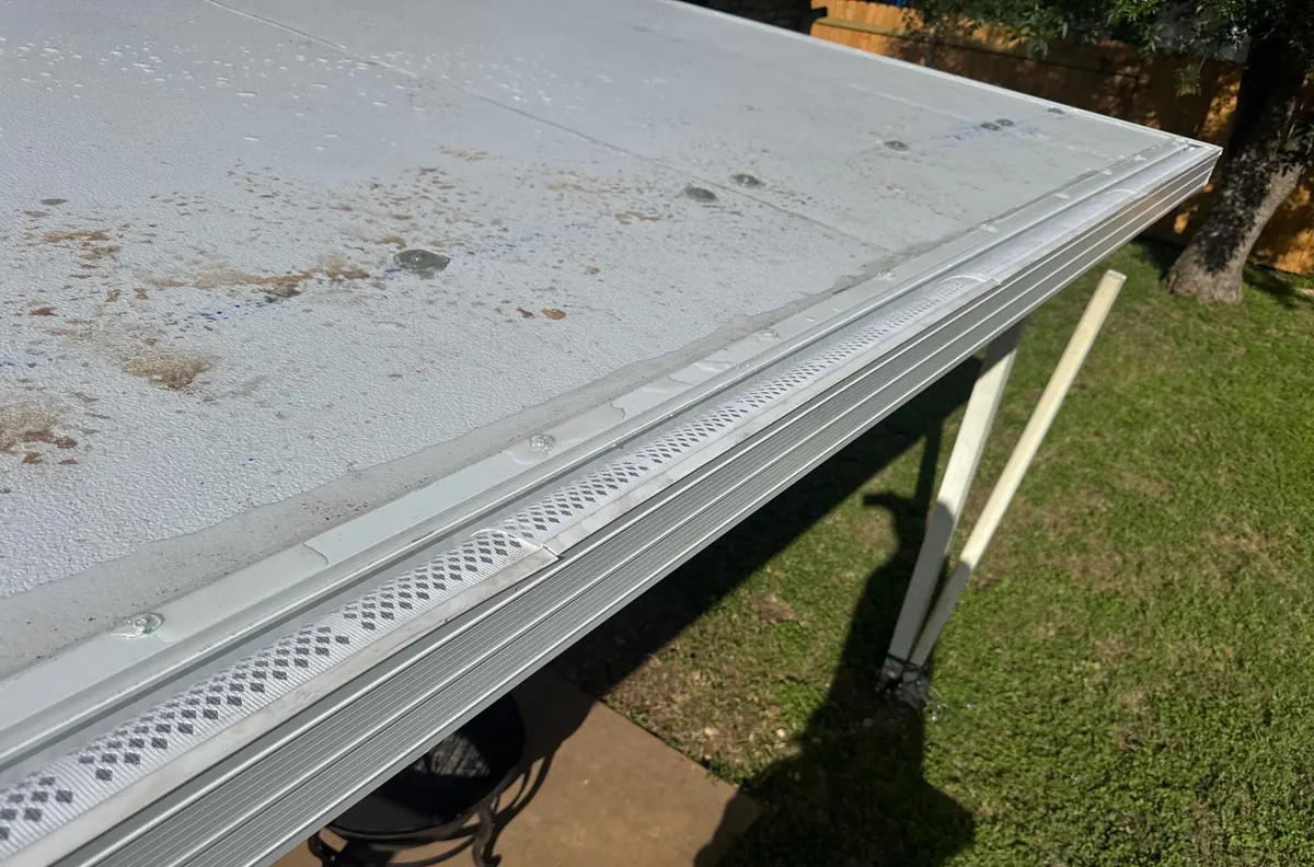 White perforated gutter guard on a white gutter